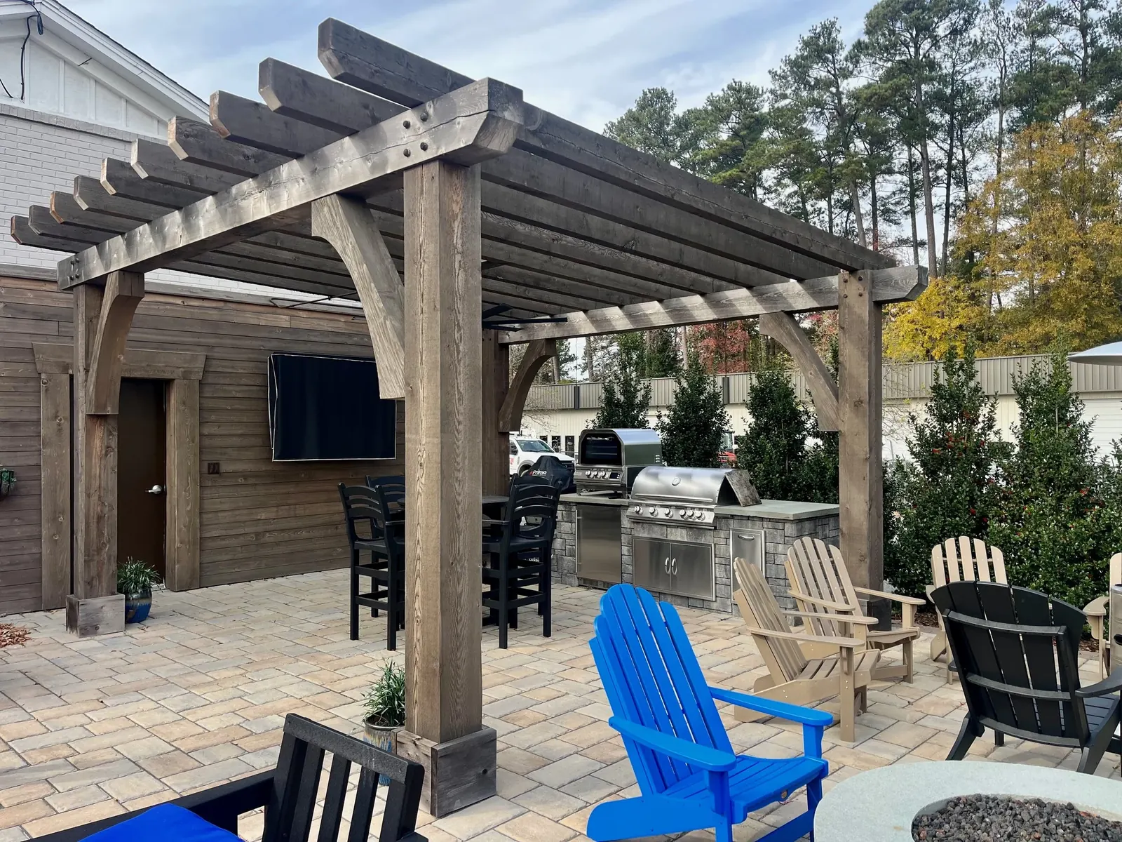 Paver patio with timber pergola, outdoor kitchen and grill built by Edge Effect Landscapes